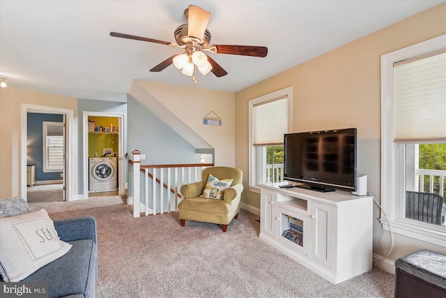 living area featuring washer / clothes dryer, carpet flooring, baseboards, and an upstairs landing