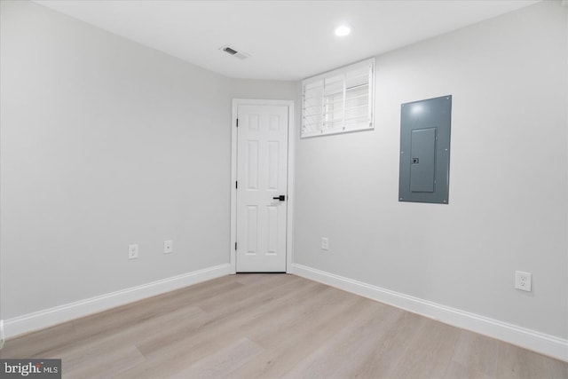 unfurnished room with light hardwood / wood-style floors and electric panel