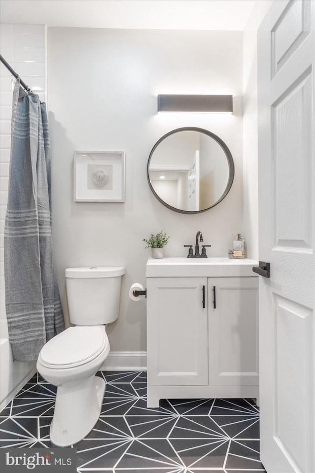 full bathroom with shower / tub combo with curtain, vanity, tile patterned flooring, and toilet