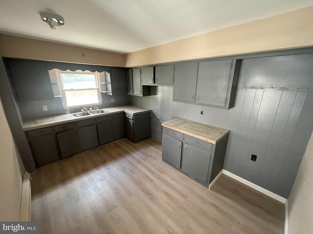 kitchen featuring gray cabinetry, light hardwood / wood-style flooring, and sink