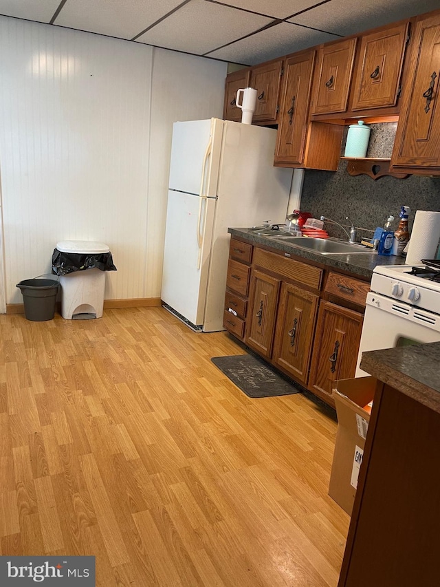 kitchen featuring a drop ceiling, light hardwood / wood-style floors, decorative backsplash, and sink