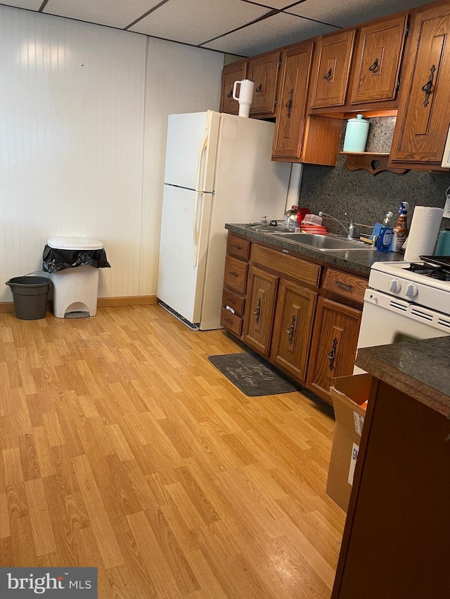 kitchen featuring a drop ceiling, backsplash, sink, light hardwood / wood-style floors, and white fridge