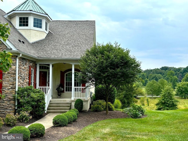 view of front of house with covered porch and a front lawn