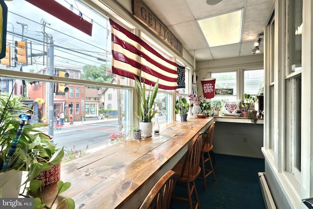 interior space with a baseboard radiator and a drop ceiling