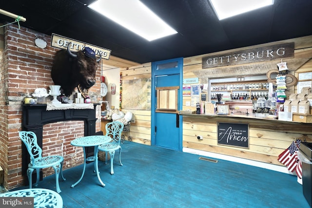 misc room featuring bar area, hardwood / wood-style floors, and wooden walls