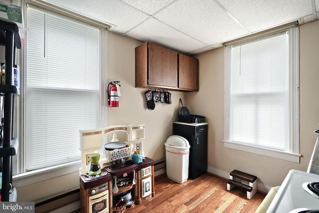 interior space with cabinets, baseboard heating, and light hardwood / wood-style floors