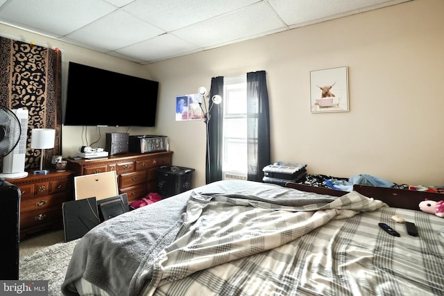 bedroom featuring a paneled ceiling and carpet flooring