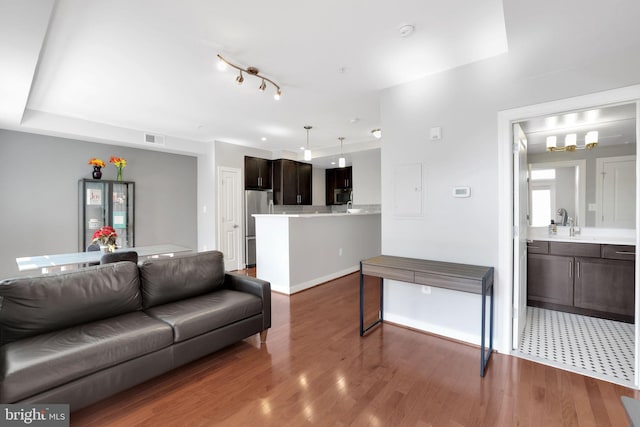 living room with dark tile patterned floors and rail lighting