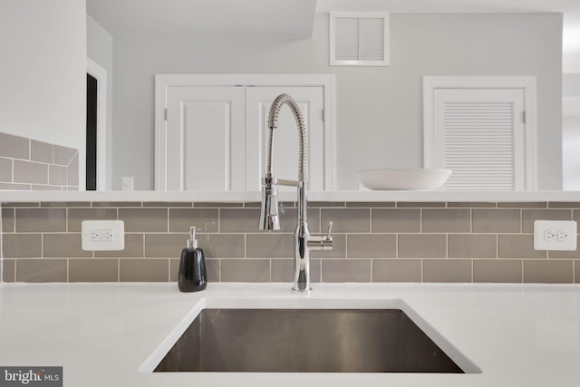 room details featuring sink and tasteful backsplash