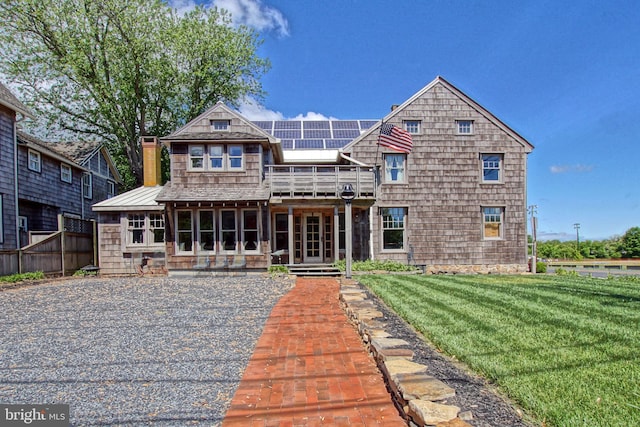 view of front of property featuring a front yard and solar panels