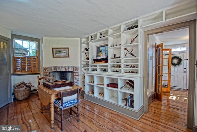 miscellaneous room featuring hardwood / wood-style flooring, a fireplace, and a textured ceiling