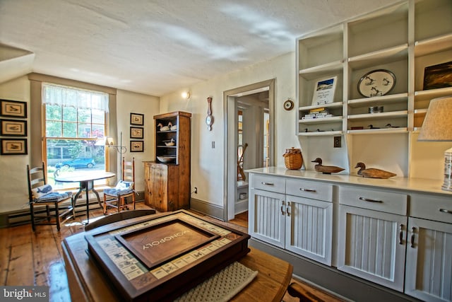 interior space featuring dark hardwood / wood-style flooring, a textured ceiling, and baseboard heating