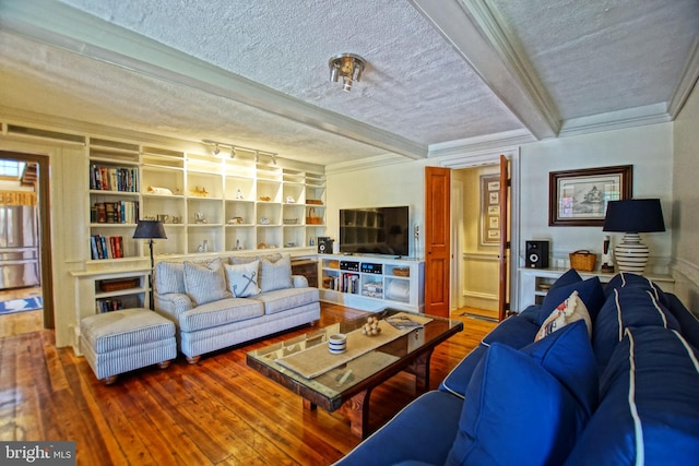 living room with built in features, beamed ceiling, wood-type flooring, crown molding, and a textured ceiling