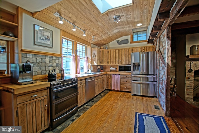 kitchen featuring sink, lofted ceiling with skylight, stainless steel appliances, tasteful backsplash, and wooden ceiling