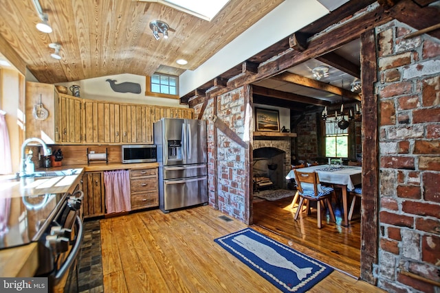 kitchen featuring stainless steel appliances, sink, wooden ceiling, and light hardwood / wood-style flooring