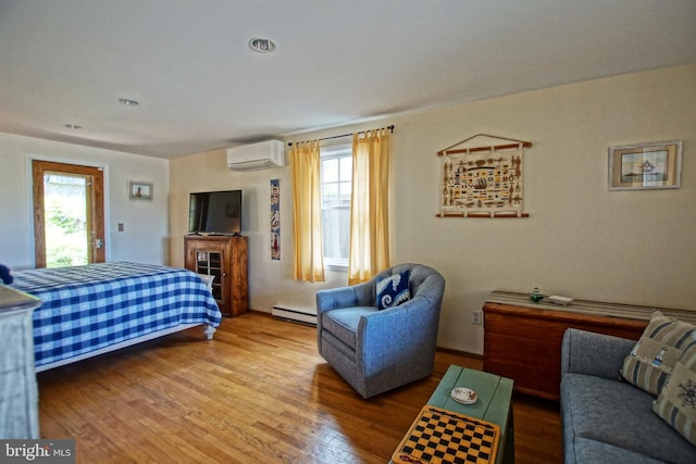 bedroom with multiple windows, a baseboard radiator, hardwood / wood-style floors, and a wall unit AC