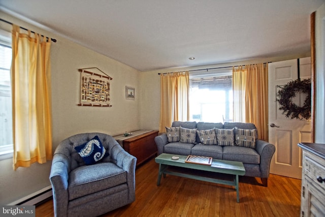 living room featuring a baseboard heating unit and hardwood / wood-style flooring