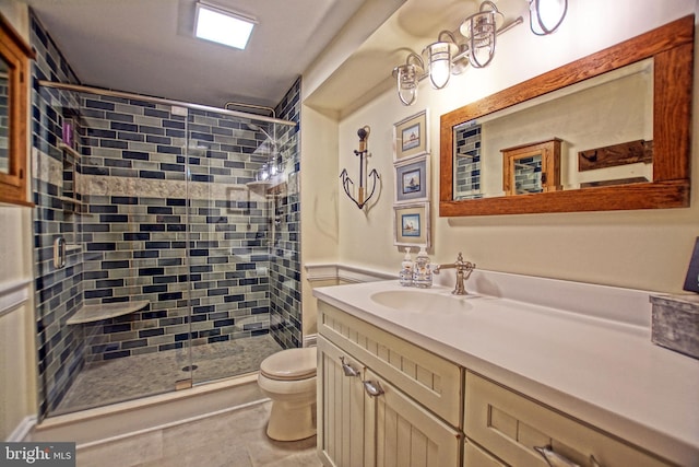 bathroom featuring vanity, toilet, an enclosed shower, and tile patterned flooring