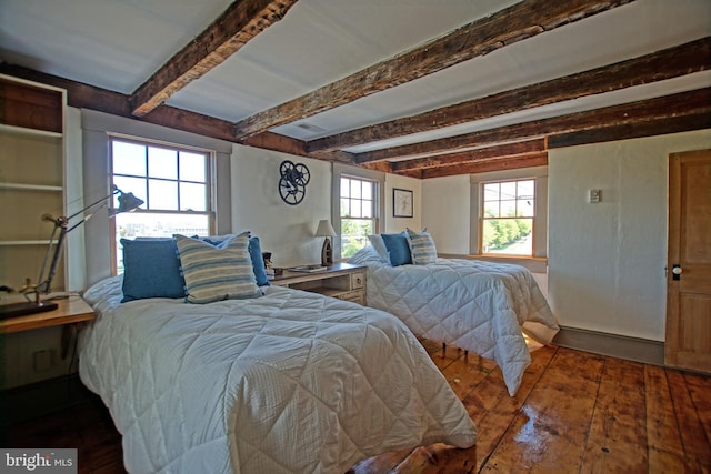 bedroom with dark hardwood / wood-style floors and beamed ceiling