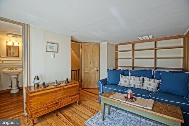 living room featuring wood-type flooring and crown molding