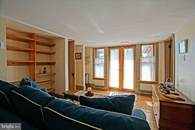 living room with a baseboard radiator, ornamental molding, light hardwood / wood-style flooring, and french doors