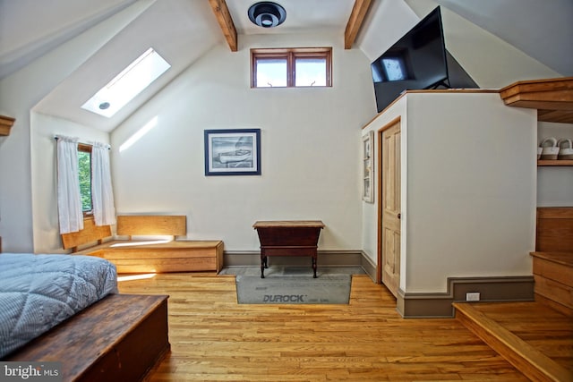 bedroom featuring beamed ceiling, high vaulted ceiling, light hardwood / wood-style floors, and a skylight