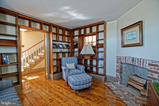 living area with hardwood / wood-style floors and a brick fireplace