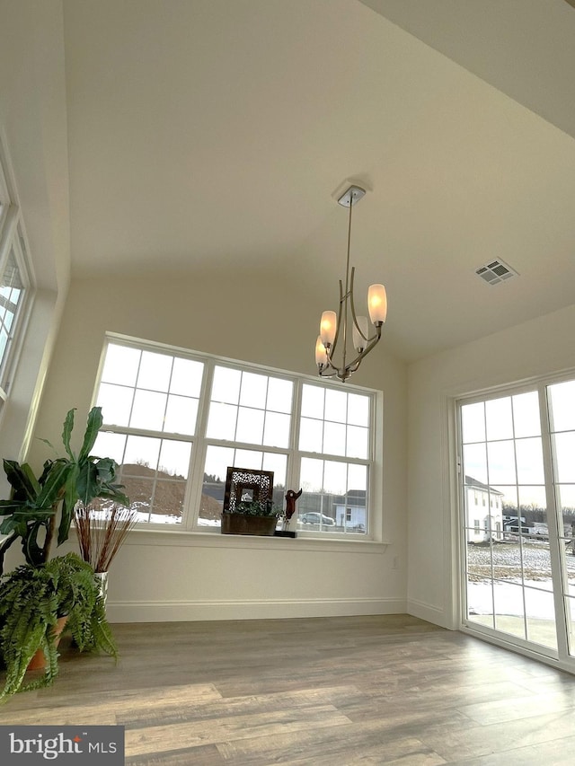 interior space with hardwood / wood-style floors, a chandelier, and a healthy amount of sunlight