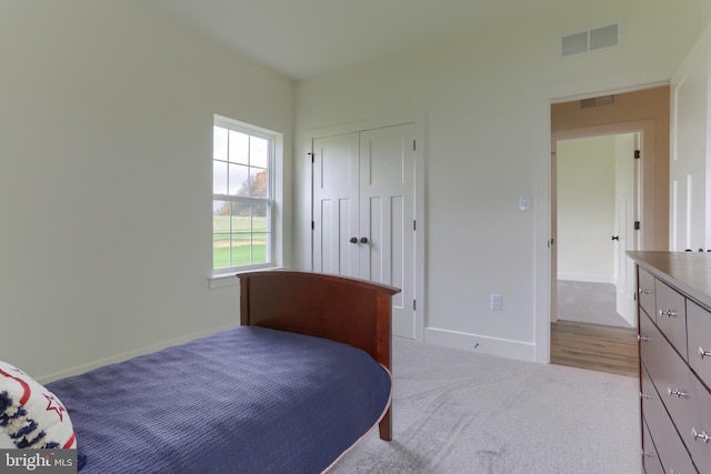 bedroom featuring a closet and light carpet