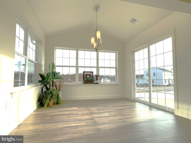 unfurnished sunroom featuring vaulted ceiling and a notable chandelier