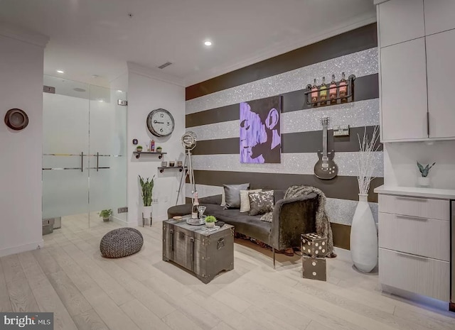 living area featuring crown molding and light hardwood / wood-style floors