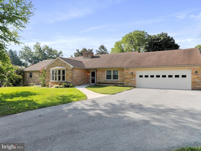 ranch-style home featuring a garage and a front lawn