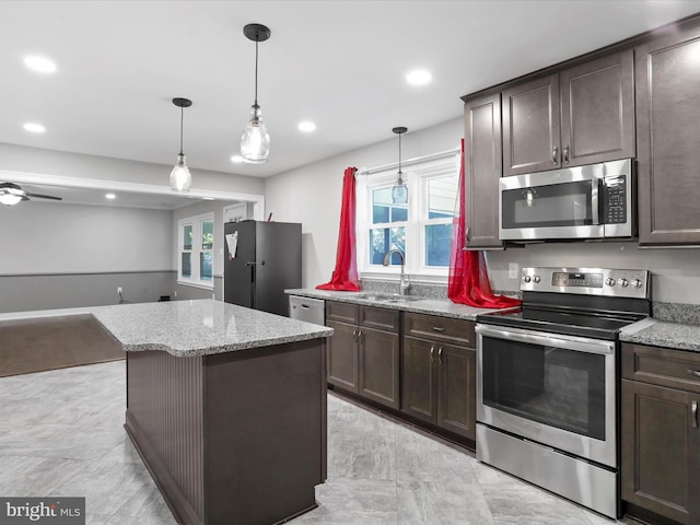 kitchen featuring dark brown cabinetry, appliances with stainless steel finishes, sink, and hanging light fixtures