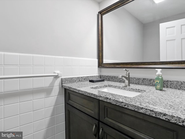 bathroom with vanity and tile walls