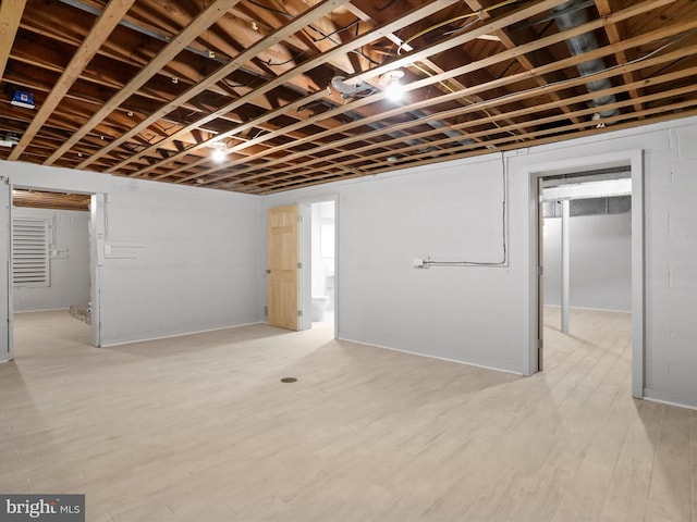 basement with light hardwood / wood-style flooring