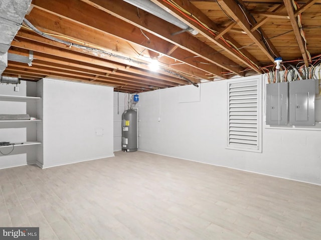 basement with hardwood / wood-style flooring, electric water heater, and electric panel