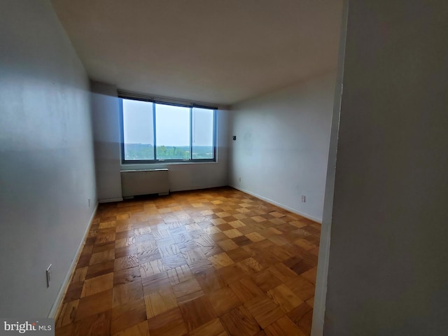 unfurnished room with light parquet floors and radiator heating unit