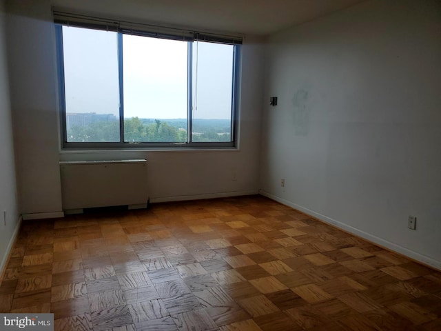 unfurnished room with light parquet flooring and radiator heating unit