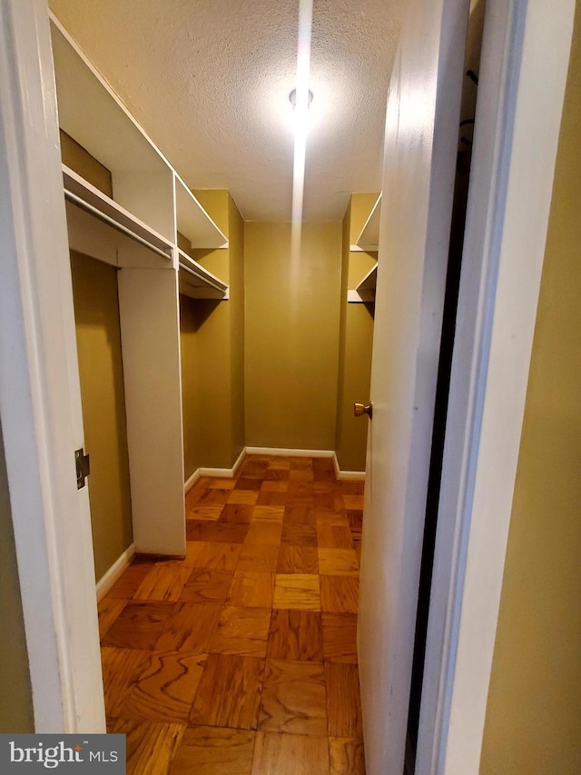 spacious closet featuring parquet flooring