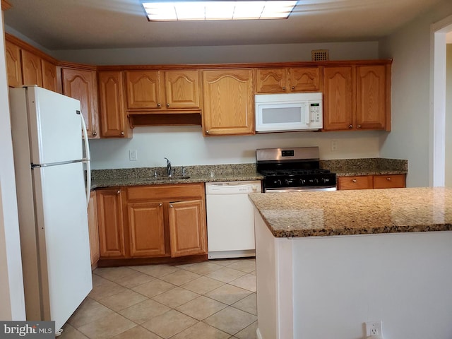 kitchen featuring light tile patterned floors, light stone countertops, sink, and white appliances