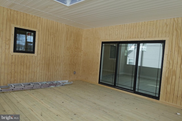unfurnished room featuring wooden walls and hardwood / wood-style flooring