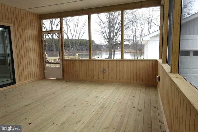 unfurnished sunroom with a water view