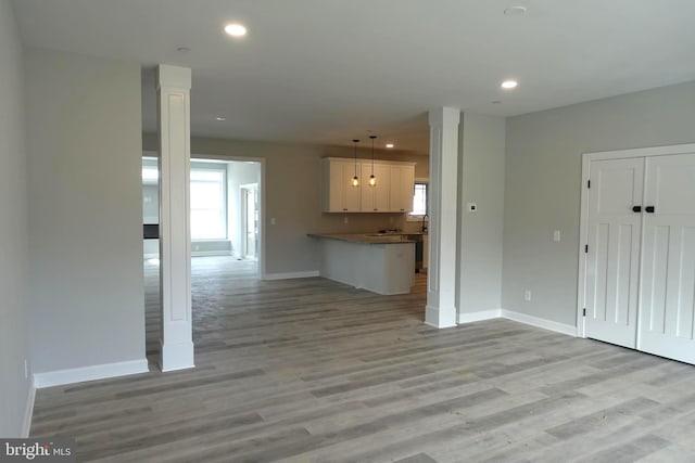 unfurnished living room with recessed lighting, baseboards, and light wood-style floors