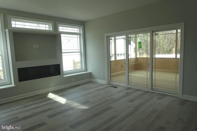 unfurnished room with baseboards and wood finished floors