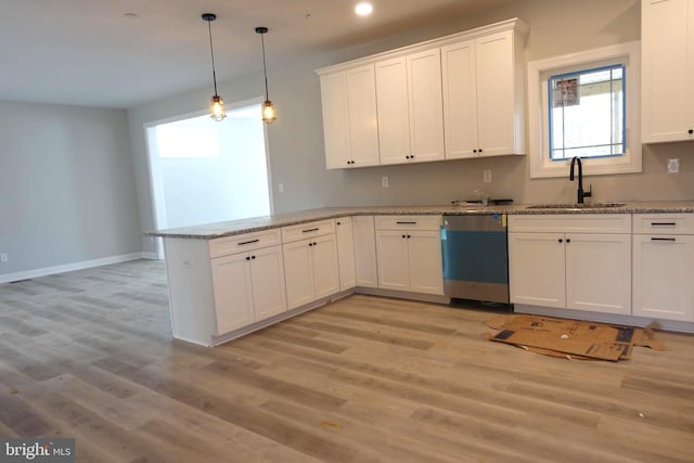 kitchen featuring dishwashing machine, white cabinets, a peninsula, and a sink