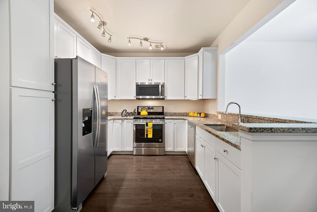 kitchen featuring light stone countertops, appliances with stainless steel finishes, sink, dark hardwood / wood-style flooring, and white cabinetry