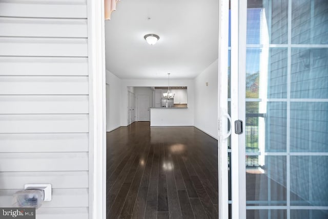 interior space with a notable chandelier and dark hardwood / wood-style flooring