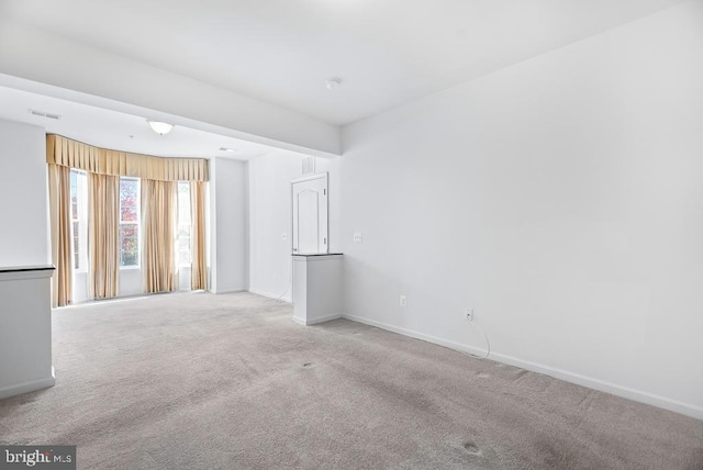 unfurnished room featuring light colored carpet