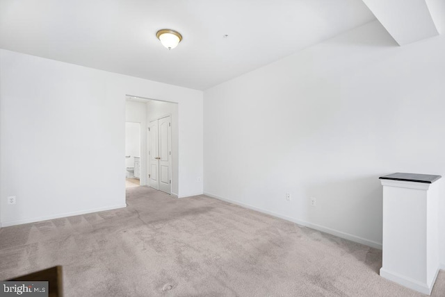 unfurnished room featuring light colored carpet