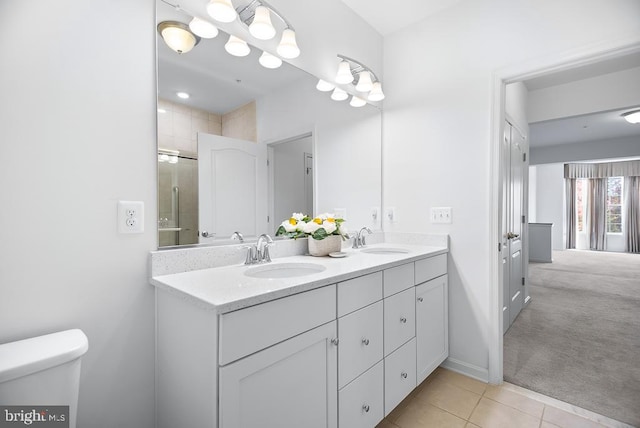 bathroom with toilet, an enclosed shower, vanity, and tile patterned flooring